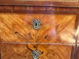an antique chest of drawers with a wooden top and brass hardware
