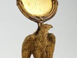 une statue représentant un aigle avec une horloge sur la tête
