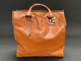 a brown leather handbag with a gold lock on the handle