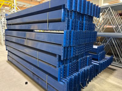 une grande pile de poutres en acier bleu dans un entrepôt