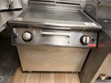 a large stainless steel grill in a commercial kitchen