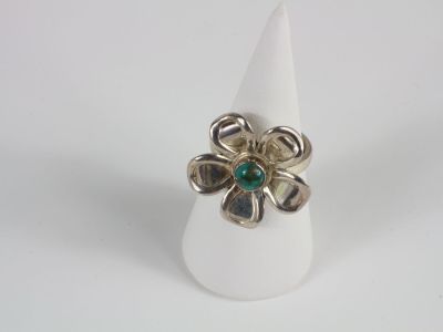 a close up of a ring with a flower on top of it