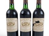 trois bouteilles de vin posées les unes à côté des autres sur une surface blanche