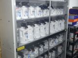 a shelf with many bottles of cleaning products on it