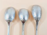 three spoons that are sitting on a table