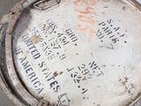 a metal container with writing on it sitting on the ground