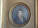 portrait d'un homme en costume et nœud papillon dans un cadre doré
