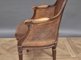 an old fashioned chair with a brown leather seat on a wooden floor