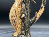 a ceramic vase with a bird on it on a table
