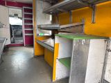 a yellow and white refrigerator and some shelves in a room