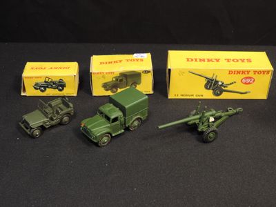 several toy army vehicles are lined up on a black surface