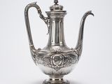 une théière ancienne en argent avec une anse, sur fond blanc