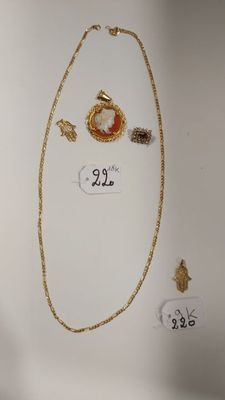 un collier en or orné d'une pierre rouge