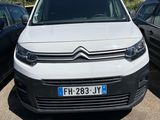 une camionnette blanche garée dans un parking à côté d'autres voitures