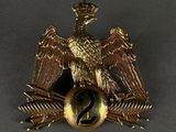 une image représentant un insigne en forme d'aigle doré sur lequel figure le chiffre 2