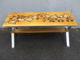 table basse carrelée, avec un motif de papillon sur le plateau et des pieds en métal
