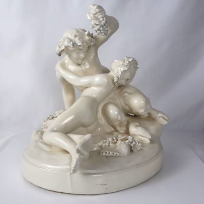 une statue représentant une femme et un enfant assis sur une table