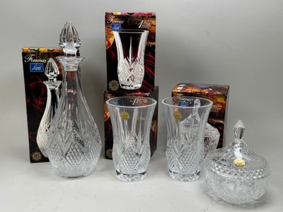 trois vases en cristal et une boîte de bonbons posés sur une table