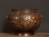a brown vase sitting on a table with a black background