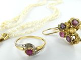 une photo représentant un ensemble composé d'un collier, d'une bague et d'une boucle d'oreille, posé sur un fond blanc
