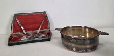 a small silver bowl and a silver spoon on a table