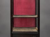 an antique wooden bookcase with red velvet lining the shelves