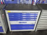 Deux caisses à outils bleues sont empilées l'une sur l'autre dans un garage.
