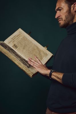 a man that is holding a book in his hands
