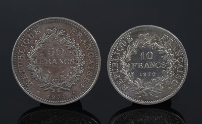 a close up of two silver coins on a black surface