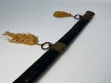 a long black pipe with a gold tassel on it