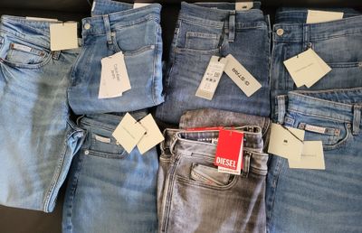 a lot of jeans that are sitting on a table