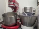 un mixeur rouge et un saladier argenté posés sur une étagère