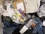 a pile of clothes and other items on a bed