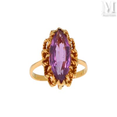 gros plan d'une bague en or avec une pierre violette