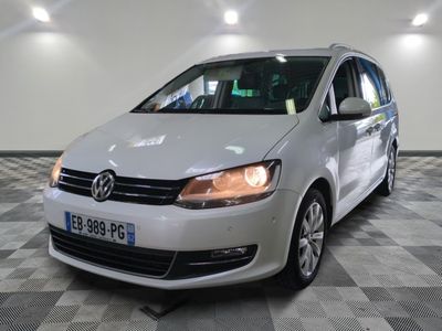 Le fourgon VW blanc est garé sur un sol carrelé à damier.