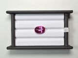 a close up of a pink diamond in a black box