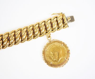 Gros plan sur un bracelet en or orné d'une pièce de monnaie
