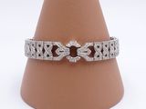 Gros plan sur un bracelet en diamants posé sur un cône, sur fond blanc