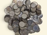 une pile de pièces d'argent posée sur une surface blanche