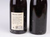 deux bouteilles de vin posées l'une à côté de l'autre sur une surface blanche