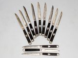 several knives are lined up in a circle on a white surface