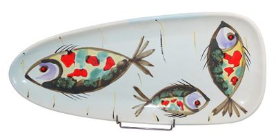 a plate with a fish design on it on a stand