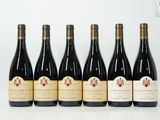 six bouteilles de vin sont alignées sur une table