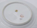 a white plate with a bird on it on a table