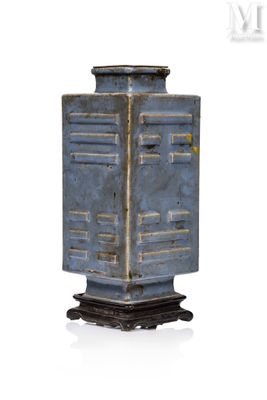 un vase bleu posé sur un socle