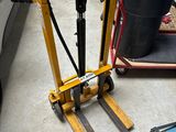 a fork lifter that is sitting on the floor in a garage