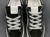 the black and white sneakers are lined up on a gray surface