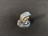 a close up of a ring on a table with a black background