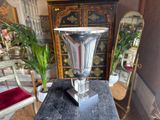 a silver vase sitting on top of a black table