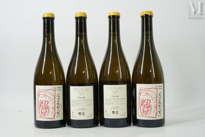 quatre bouteilles de vin sont alignées sur une table